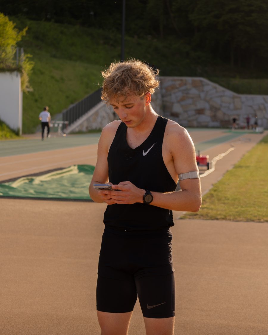 Leichtathlet trägt nach dem Training am Handy seine Einheit ein