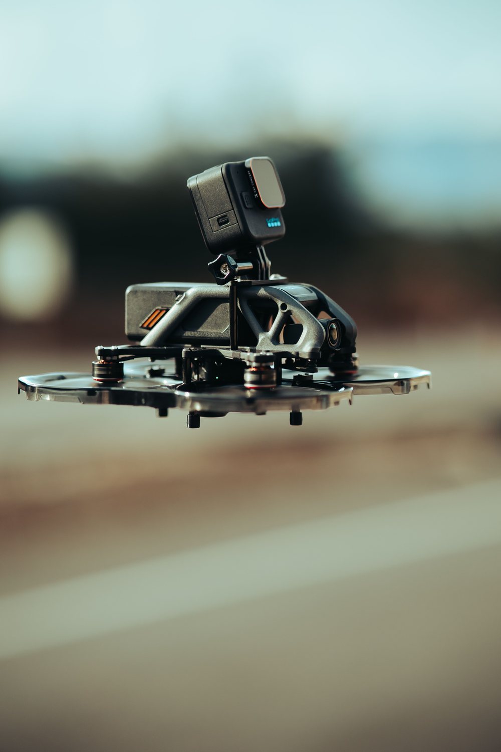 FPV-Drohne mit Propellerschutz und aufgesetzter Kamera im Schwebeflug